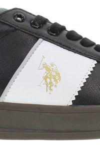 Czarno-białe trampki z złotym logo polo, cholewka z teksturowanej skóry, okrągłe sznurowadła i trwała gumowa podeszwa.