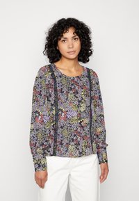 Blusa de manga longa com flores, apresentando um fundo escuro com flores roxas, verdes e vermelhas, complementada por realces verticais escuros.
