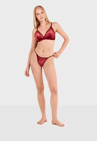Ensemble de lingerie en velours bourgogne comprenant un bralette avec une finition en dentelle et un thong assorti, design minimaliste avec des fines bretelles et une finition lisse.
