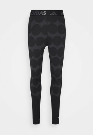 Czarne legginsy sportowe z dużym wzorem w kropki, elastyczny materiał, szeroki pas w talii z logo Adidas oraz dopasowany krój.