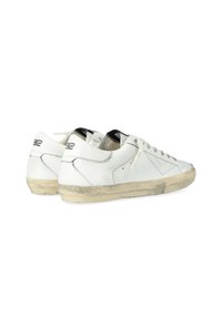 Sneaker bianche in pelle con design a taglio basso, suola in gomma color crema, punta rotonda, chiusura con lacci e dettagli del logo neri sul tallone.