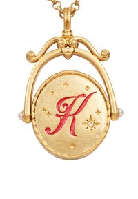 Gouden hangersketting met een ronde medaillon waarin een rood gestileerde "K" is afgebeeld, omgeven door kleine sterren en geaccentueerd met parels.