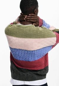 Knit sweater featuring horizontal stripes in green, pink, blue, red, and gray with textured patterns and a ribbed collar and cuffs.