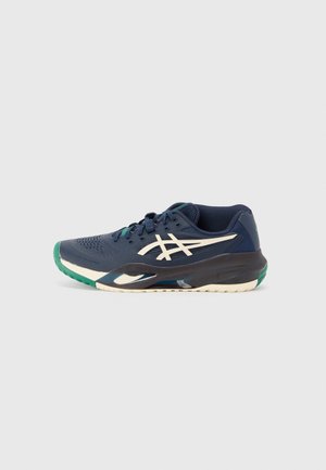 Navy athletic shoe with mesh upper, white logo, green accent on toe, and a multicolored sole. Streamlined design with textured surface.