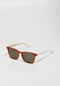 Ochelari de soare pătrați cu o ramă din întrebuințare tortoiseportocalie, lentile gri și brațe de culoare crem cu accente din metal.