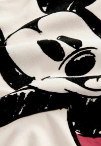 Tissu en coton noir et blanc présentant une impression graphique d'un personnage de dessin animé avec des traits et textures faciaux notables.