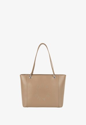 Beżowa torba typu tote z faux skóry z dwoma długimi uchwytami i okrągłym, ozdobionym ćwiekami wzorem na froncie. Gładka faktura i usztywniony kształt.
