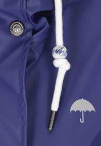 Marinblå vattentät jacka med en vit dragkedja som har en dekorativ blå och vit pärla, metallisk detalj och silverfärgad paraply-logotyp.