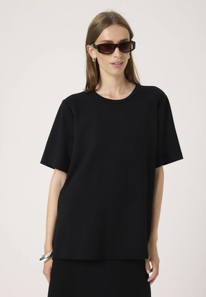 Sort kortærmet T-shirt lavet af bomuld, med en løs pasform og en rund halsudskæring. Stoffet fremstår glat uden synlige mønstre.