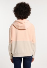 Hoodie met een ribbelstructuur, in perzik- en beige kleurblokken, met een relaxed fit en zijzakken.