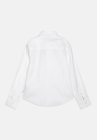 Camisa branca de manga longa com colarinho clássico, costura na parte de trás, hem arredondado e punhos com botão. Feita de tecido suave com um acabamento limpo.