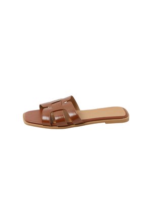 Brun læder flad slip-in sandal med åben tå og udskåret remdesign, med kvadratisk tå og lys tan sål.