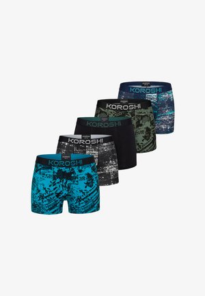 Mandlig overkrop iført grå boksershorts med sorte abstrakte mønstre og teksten "KOROSHI" på linningen mod en ensfarvet baggrund.