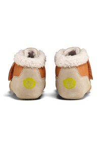 Botas de tobillo de cuero marrón con un forro suave de color crema. Cuentan con una correa de velcro y un logo verde en el talón. Materiales de ante y texturizados.