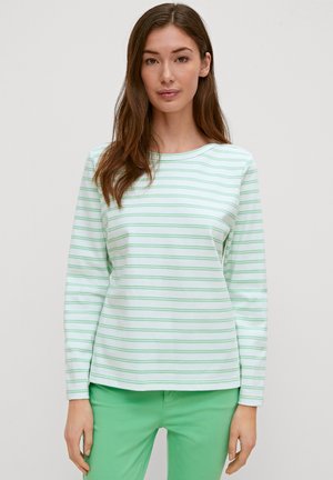 Langarmshirt in Hellgrün mit dünnen weißen Streifen, aus weichem Stoff. Runder Halsausschnitt und lockere Passform, kombiniert mit grünen Hosen.
