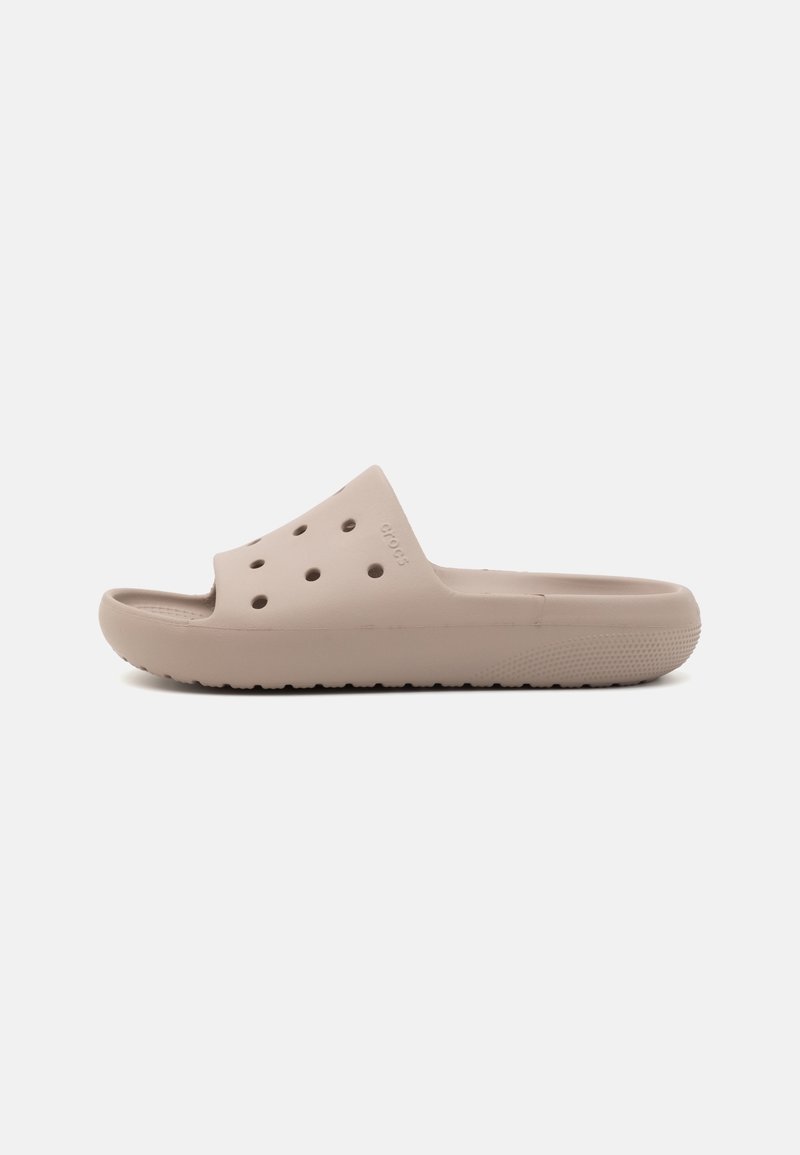 Beige gummisandal i slide-stil med åben tå, ventilationshuller, en tykk sål og en struktureret bund for bedre greb.