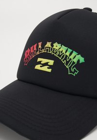 Svart keps med flerfärgad broderad text som står "BILLABONG" och en logotyp. Materialet är slätt med en strukturerad, böjd skärm.