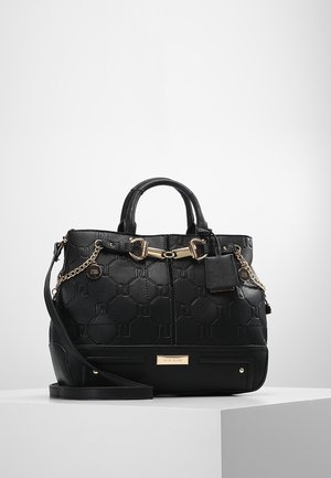 Czarna torebka ze skóry o fakturze, z detalami w postaci złotego łańcuszka i klamry, krótkimi uchwytami oraz odpinanym paskiem na ramię, na białym tle.