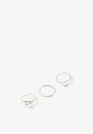 Drie zilveren ringen in verschillende stijlen: een brede band met een textuur, een eenvoudige dunne band en een vierkant gevormde band.