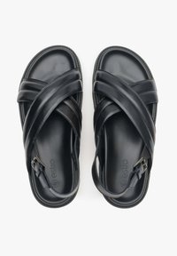 Černé kožené sandály s designem s křížovými popruhy, plochou podrážkou a nastavitelnou přezkou. Hladký povrch a minimální značení.