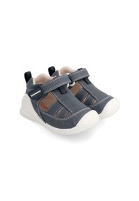 Kinderschuhe aus dunkelblauem Stoff mit weißer Gummisohle. Verfügen über Klettverschlussriemen und gestickte Details. Offenes Design für Atmungsaktivität.