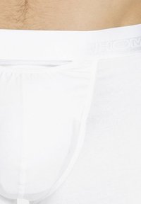 Boxer in cotone bianco caratterizzati da una vestibilità aderente, una vita elasticizzata con logo del marchio e una texture liscia. Nessun motivo o accento visibile.
