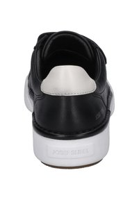 Sneaker in pelle nera con suola in gomma bianca, caratterizzata da una texture liscia e un accento sul tallone in beige. Logo del brand sul retro.