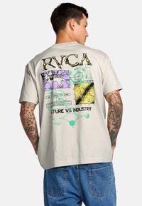 Grijze katoenen t-shirt met een kleurrijke grafische print op de achterkant. Het ontwerp bevat vetgedrukte tekst en abstracte patronen. Korte mouwen.