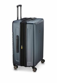 Harde koffer in donkergrijs met een gestructureerde afwerking, voorzien van een zwarte ritssluiting, een uitschuifbare handgreep en vier spinwielen.