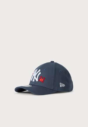 Marineblaue Baseballmütze mit weißem NY-Logo und kleiner roter Krabbenstickerei auf der Vorderseite, mit New Era-Logo an der Seite.