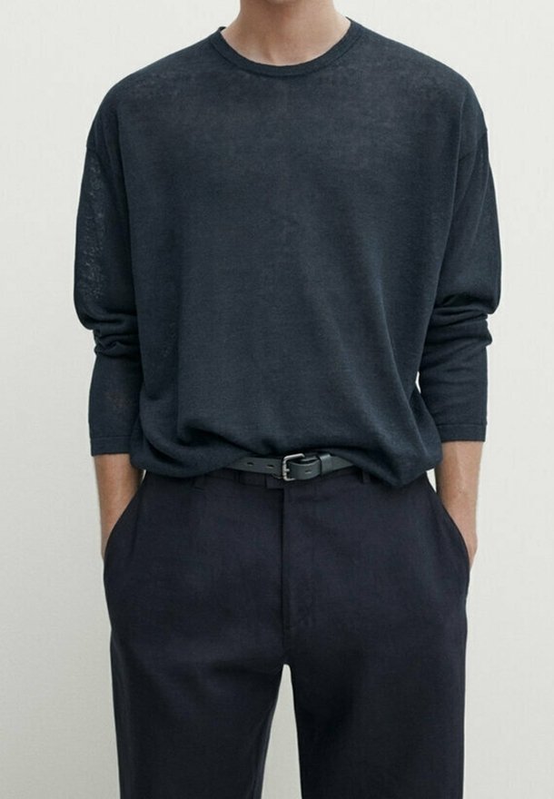 T-shirt a maniche lunghe di un blu navy scuro realizzato in tessuto leggero, con scollatura rotonda e vestibilità rilassata, abbinato a pantaloni scuri su misura.