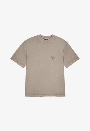 T-shirt in cotone marrone chiaro con maniche corte, scollatura rotonda e un piccolo logo circolare sul petto. Texture liscia.