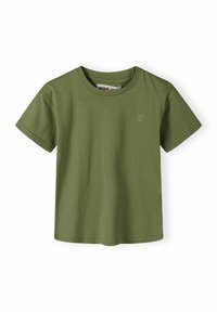 Camiseta de manga corta color verde oliva con cuello redondo y pequeño emblema claro en la zona del pecho izquierdo, mostrada sobre fondo blanco.