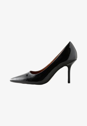 Pantof de damă cu toc înalt din piele lacuită neagră, cu vârf ascuțit și toc stiletto subțire, văzut din profil pe fundal alb.