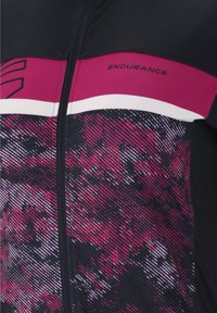 Kortärmad cykeltröja i svart och magenta. Har ett geometriskt mönster och dragkedjestängning. Materialet är lätt och stretchigt.
