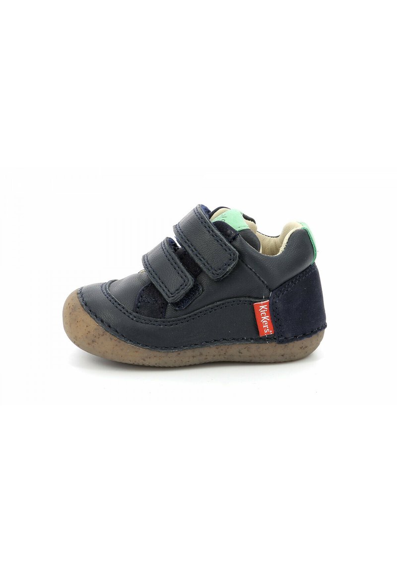 Chaussure pour tout-petits en cuir marine avec deux bandes Velcro, accent vert au talon et semelle marron texturée. Détails en couture présents.