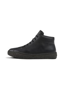 Zapato negro de cuero de caña alta con suela de goma negra texturizada, que presenta un diseño simple de cordones y una parte superior lisa y sin costuras.