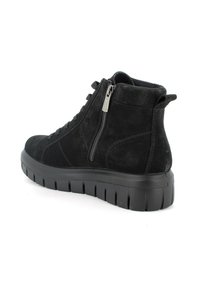 Stivali alla caviglia in suede nero con suola in gomma spessa, chiusura con lacci e zip, punta rotonda e dettagli testurizzati sui lati.