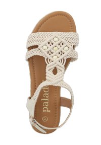 Sandali intrecciati beige con design aperto, caratterizzati da perline decorative bianche e una soletta marrone. Cinghia regolabile con dettaglio in metallo.
