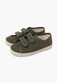 Green canvas shoes with dual Velcro straps, round toe, white rubber sole, textured surface, and contrasting stitching detail.
