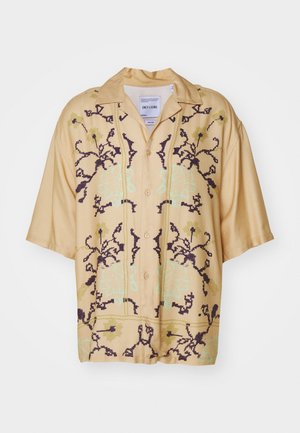 Short-sleeve button-up shirt in light beige fabric, featuring a floral pattern in dark purple and mint green. Classic collar design.