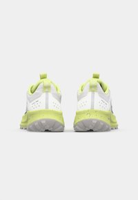 Witte en limoen groene hardloopschoenen met een gestructureerde bovenkant, een gevoerde kraag en een gespikkelde middenzool. Achterste trekriem voor eenvoudig aan- en uittrekken.
