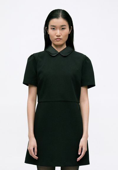 Robe noire à manches courtes avec un col arrondi et un corsage structuré. La jupe s'élargit légèrement à l'ourlet, fabriquée en tissu lisse. Design minimal.