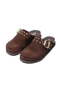 Sabots en suède marron à enfiler avec des clous dorés, une grande boucle dorée sur le côté, et une semelle en liège avec un fond cranté.