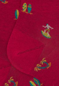 Calze fucsia con motivi di tavole da surf, palme e un surfista, realizzate in un morbido materiale lavorato a maglia con una fine texture.
