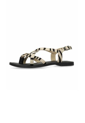 Sandaal met platte zwarte zool en zebragestreepte gekruiste banden met verstelbare gespsluiting op witte achtergrond.