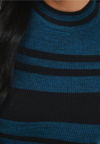 Sweter z dzianiny z poziomymi paskami w ciemnoniebieskim i czarnym kolorze, o prążkowanej teksturze i wysokim dekolcie.