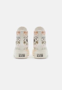 High-top Converse All Star sneakers with animal print patterns including tigers and leopards, shown from the back on a white background.