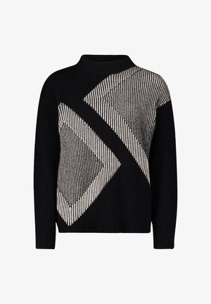 Schwarzer Strickpullover mit großen diagonalen grauen und weißen geometrischen Mustern. Der hohe Kragen und die langen Ärmel betonen das strukturierte Aussehen.