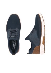 Marineblau Sport Schuhe mit einem Obermaterial aus Mesh, einer strukturierten braunen Akzentfläche, einer weißen Gummisohle und Schnürverschluss.